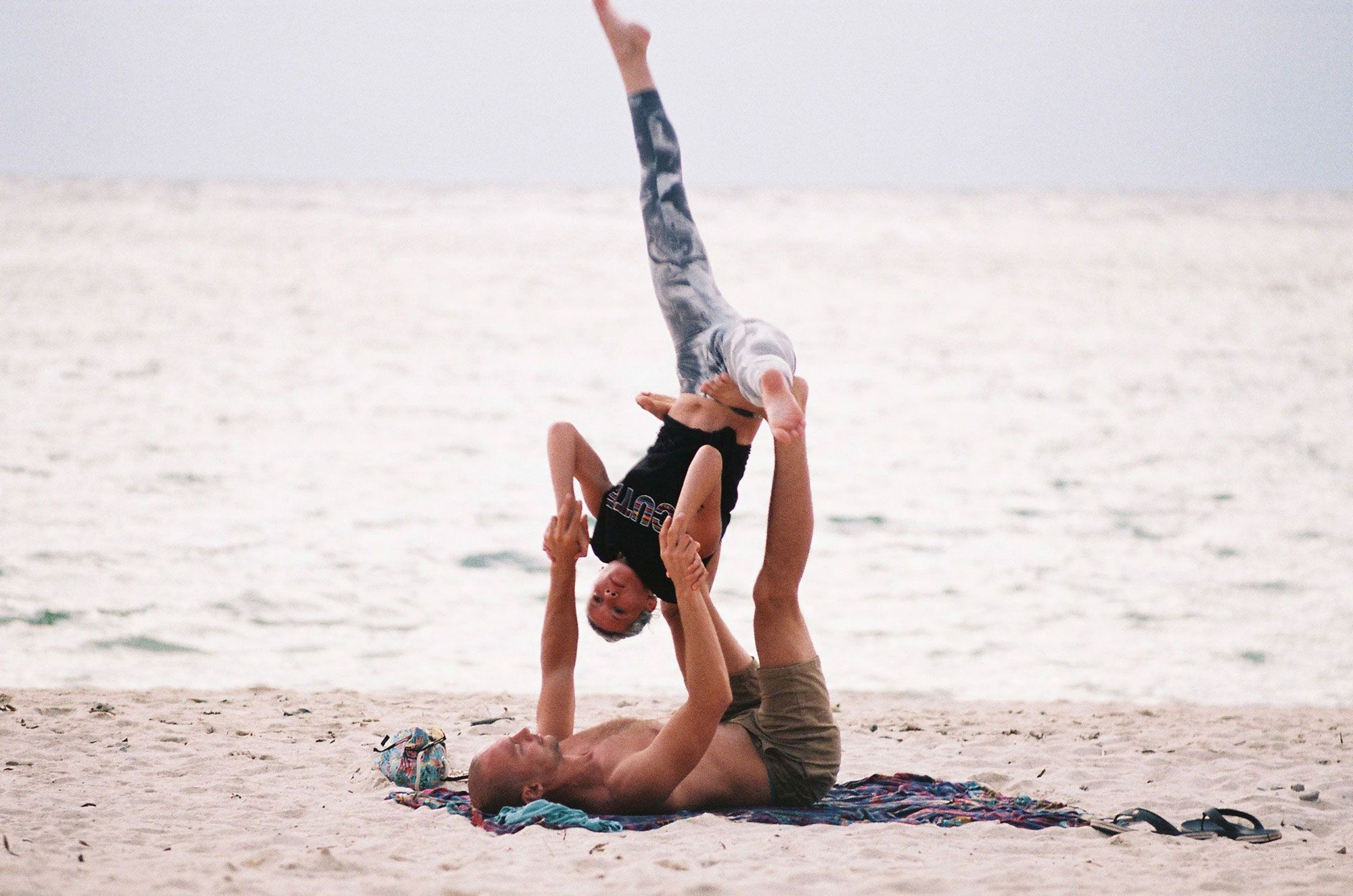 Couple Doing Yoga on the Beach Couple Doing Yoga on the Beach